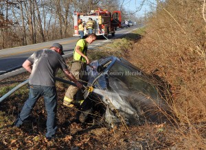 A crew from Firebrick Fire and Rescue extinguish a fire following an accident on Ky. Rt. 8 at Firebrick. - Photo by Dennis Brown