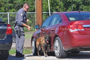 KSP Trooper Brandon Eversole and his partner check autos in the parking area at LCHS during a sweep at the facility last week. - Photo by Dennis Brown