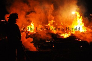 A firefighter keeps a close eye on a barn fire at Rock Run late Friday. The cause of the fire is under investigation. - Dennis Brown Photo