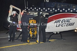 Emergency responders load a patient onto a medical helicopter following a single vehicle accident on the AA Highway at Garrison early Thursday. - Dennis Brown Photo