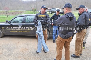 Sheriff Johnny Bivens, center, confers with deputies during the execution of a search warrant at a residence near Garrison. - Dennis Brown Photo